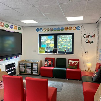seddi coch mewn cylch a theledu ar y wal