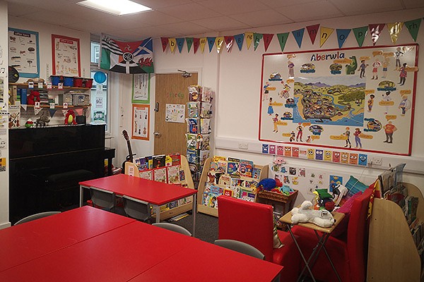 Ystafell dosbarth lliwgar gyda byrddau a cadeiriau coch