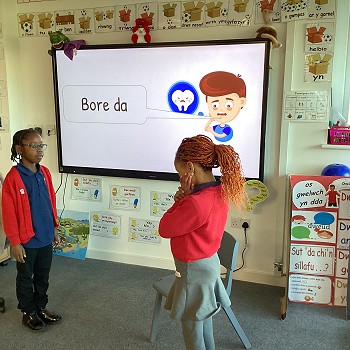 2 students learning how to say good morning in welsh