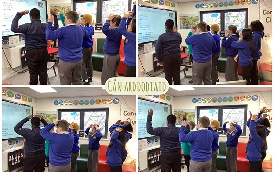 group of students following a song on the white board